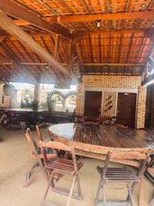 a large wooden table and chairs in a room at Pousada e Chalés mar e sol in Manibu