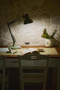 a desk with a lamp and a book and a glass of wine at B&B Magnolia Centro Storico Grottaglie in Grottaglie