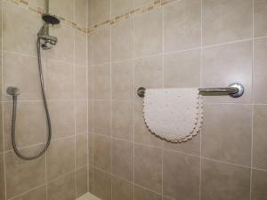 a bathroom with a shower with a white towel at Honeysuckle Rise in Looe +12 photos