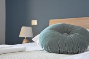 a blue pillow sitting on top of a bed at Thalore room e apartments in Amantea +25 photos
