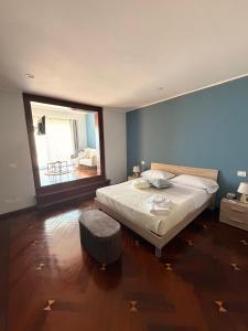 a bedroom with a large bed and a large window at Thalore room e apartments in Amantea