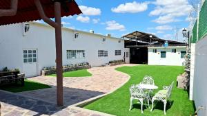 a patio with a table and chairs on a lawn at Hotel La Leyenda Sonora in El Saucito