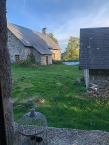 a yard with an old building and a bird cage at La maison de Jeanne La Monédière in Chaumeil