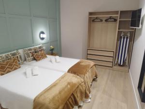 two beds in a small room with a closet at Aqua Celenis in Caldas de Reis