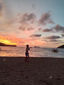a woman standing on the beach at sunset at Llave transient 2 in Nasugbu