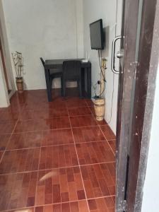a room with a tiled floor with a table and a television at Llave transient 2 in Nasugbu