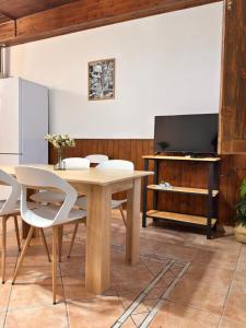 a dining room with a table and a tv at Casa sul mare da Giovanna in La Caletta