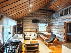 a living room with wooden walls and a couch and a table at Isokelo Log Apartments in Salla +206 photos