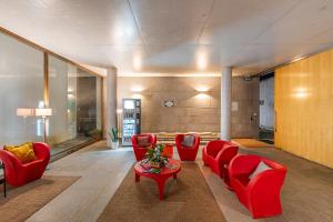 a living room with red chairs and a table at HI Ponte de Lima - Pousada de Juventude in Ponte de Lima