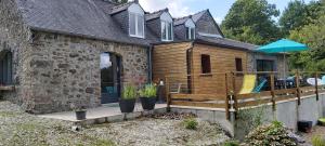 a house with a wooden deck with an umbrella at Gîtes de Botplançon in Saint-Aignan