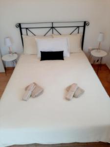 a white bed with two slippers on it at Golden Sunset Villa in Tatlisu +15 photos