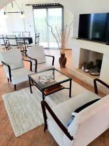 a living room with white furniture and a fireplace at Golden Sunset Villa in Tatlisu
