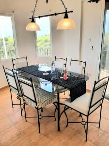 a dining room with a black table and chairs at Golden Sunset Villa in Tatlisu