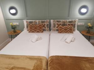 two twin beds in a room with two tables at Aqua Celenis in Caldas de Reis