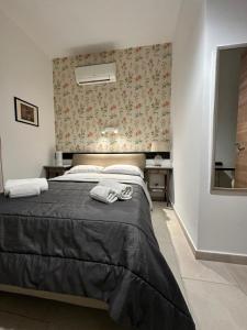 a bedroom with a bed with two towels on it at Ostello City In Hostel B&B in Catania