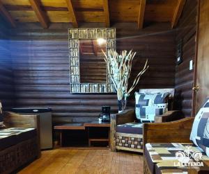 a room with two beds and a table and a mirror at Hotel La Leyenda Sonora in El Saucito