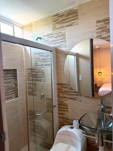 a bathroom with a shower and a sink and a mirror at Hotel Sun Suite in Barranquilla