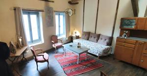 a living room with a couch and a table at L'Escalier des Rêves - Rose in Saint-Sauveur-en-Puisaye