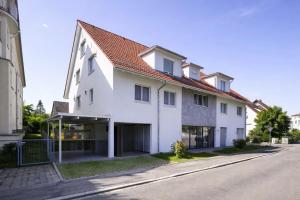 a white house on the side of a street at Zentrales Apartment in Friedrichshafen mit Terrasse für bis zu 5 Personen in Friedrichshafen