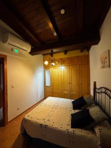 a bedroom with a large bed with a wooden ceiling at Casa rural Chantal in San Martín de Trevejo