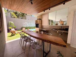 a kitchen with a large wooden table and chairs at Casa 10 Floresta Boa Vista - Piscina Privativa, Adega e Conforto em 4 suítes in Teresópolis