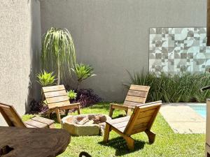 a patio with two chairs and a fire pit at Casa 10 Floresta Boa Vista - Piscina Privativa, Adega e Conforto em 4 suítes in Teresópolis