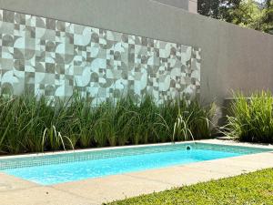 a small swimming pool in front of a wall at Casa 10 Floresta Boa Vista - Piscina Privativa, Adega e Conforto em 4 suítes in Teresópolis