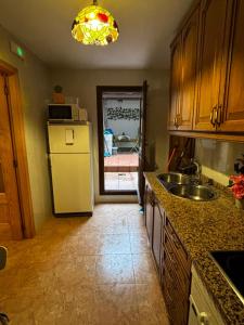 a kitchen with a white refrigerator and a sink at Casa rural Chantal in San Martín de Trevejo