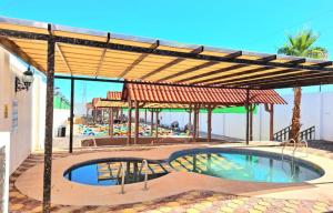 a swimming pool under a wooden pergola with a swimming pool at Hotel La Leyenda Sonora in El Saucito