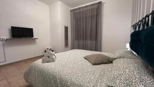 a bedroom with a bed with two stuffed animals on it at Casa Verdi in Corleone