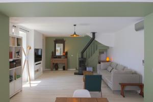 a living room with a couch and a table at "La Villa Gozforn" avec piscine privée, plages et commerces de la station balnéaire de Beg-Meil à pied! in Fouesnant