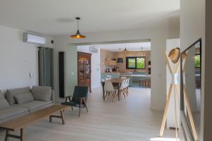 a living room with a couch and a table at "La Villa Gozforn" avec piscine privée, plages et commerces de la station balnéaire de Beg-Meil à pied! in Fouesnant
