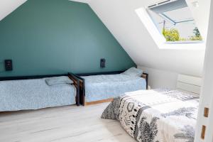a attic room with two beds and a window at "La Villa Gozforn" avec piscine privée, plages et commerces de la station balnéaire de Beg-Meil à pied! in Fouesnant +55 photos