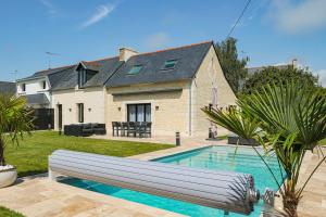 a swimming pool in front of a house at "La Villa Gozforn" avec piscine privée, plages et commerces de la station balnéaire de Beg-Meil à pied! in Fouesnant