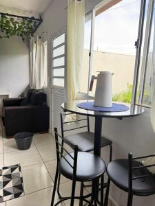 a table and chairs in a room with a window at rafaela cardoso souza in Água Boa