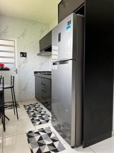 a kitchen with a stainless steel refrigerator and a table at rafaela cardoso souza in Água Boa
