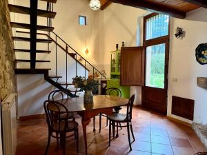 a dining room with a table and chairs and a staircase at Casa Fochita in Gratteri