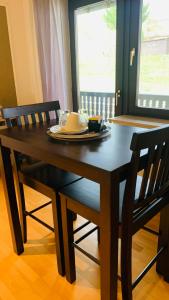 a dining room table with two chairs and a table with a plate at Comfort Doppelzimmer mit Balkon und Blick ins Grüne in Mespelbrunn