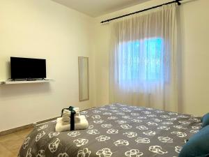 a bedroom with a bed and a tv and a window at Casa Verdi in Corleone