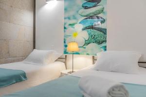 two beds in a room with a painting on the wall at HI Ponte de Lima - Pousada de Juventude in Ponte de Lima +53 photos