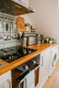 a kitchen with a stove top oven next to a washer at Gwens House in Brynsiencyn