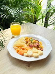 a plate of food on a table with a glass of orange juice at Hotel Sun Suite in Barranquilla +10 photos