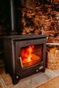 a wood stove with a fire in it at Gwens House in Brynsiencyn +24 photos