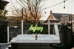 a bath tub with two bottles of beer in it at Gwens House in Brynsiencyn