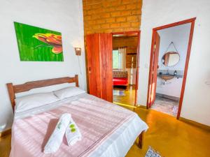 a bedroom with a bed with two towels on it at Sítio Embaú in Carrancas