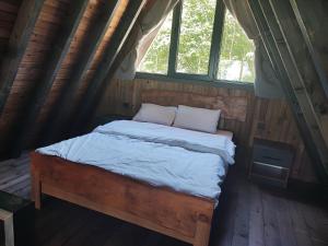 a bed in a wooden room with a window at İtenicibungolow in Korgan