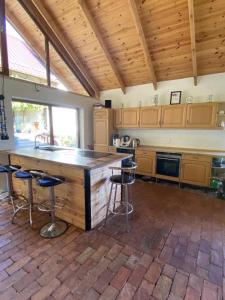 une grande cuisine avec un grand comptoir et des tabourets de bar dans l'établissement Agrowinnica, à Borzytuchom