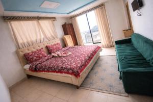 a bedroom with a bed and a couch and a window at Hotel Crown Palace in Dunga Gali