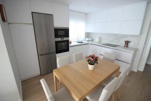 a kitchen with a wooden table with a vase of flowers on it at Atardecer en el Jerte in Cabezuela del Valle