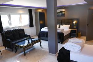 ein Hotelzimmer mit einem Bett, einer Couch und einem Tisch in der Unterkunft NRING VILLA Adenau in Adenau